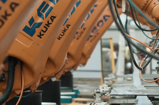 Automated robotic arms handling tiles on a ceramic production line at the Ceraglow factory