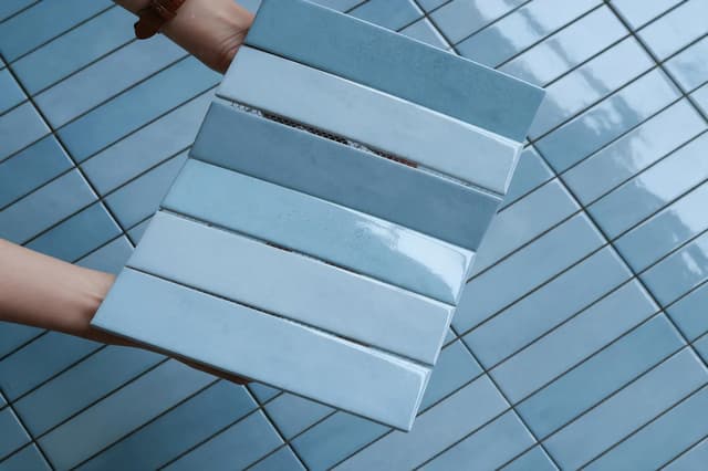 Blue glazed subway tile samples displayed over a matching small-format tiled surface