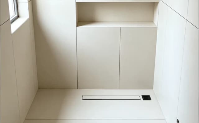 Large format porcelain wall and floor panels in a minimal walk-in shower