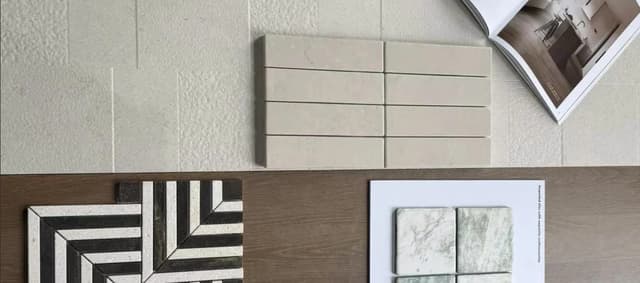 Porcelain and ceramic tile samples arranged with an interior design catalog
