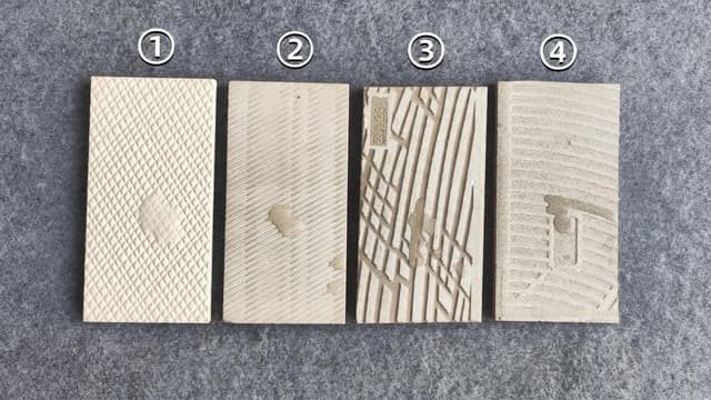 Four ceramic tile specimens showing different water absorption behavior during a comparison test