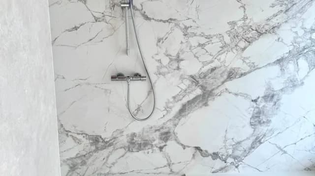 Completed marble-look shower wall tile detail in a Nairobi villa bathroom