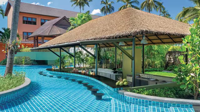 Blue mosaic tiles surrounding a swim-up bar at a tropical Phuket resort pool