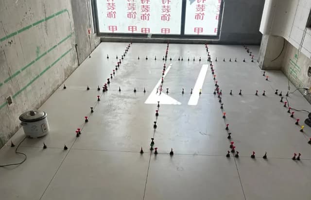 Large-format floor tiles being installed with levelling clips