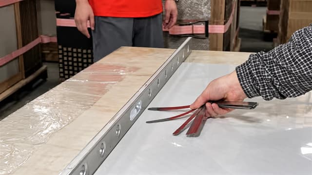 Porcelain tile flatness checked with a straightedge and feeler gauges