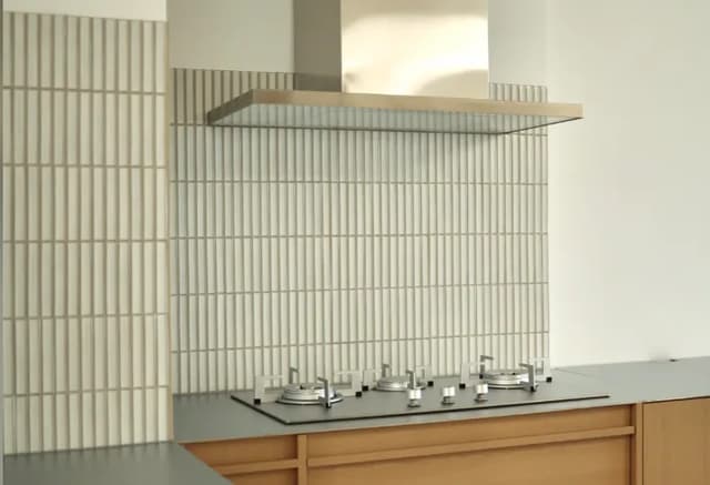 Vertical fluted wall tiles installed as a kitchen cooktop splashback