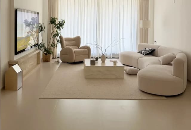 Large-format light floor tiles in a softly furnished residential living room